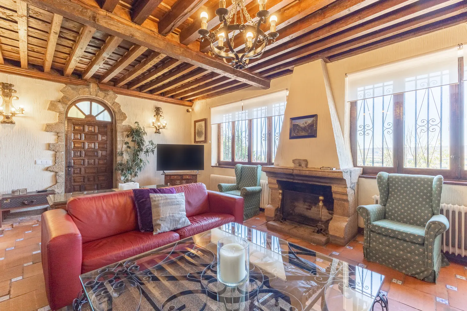 Salón de estilo castellano con vigas de madera y chimenea